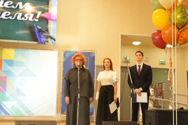 На фотографии учительница держит грамоту, а рядом с ней стоит директор гимназии..