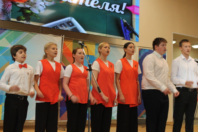 На фотографии учительница держит грамоту, а рядом с ней стоит директор гимназии..