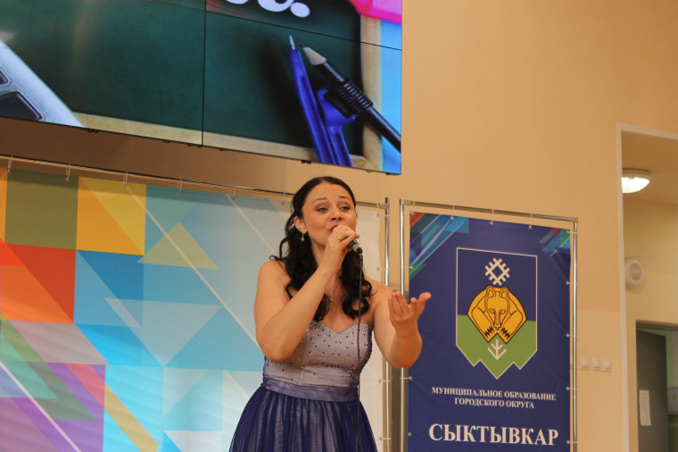 На фотографии учительница держит грамоту, а рядом с ней стоит директор гимназии..