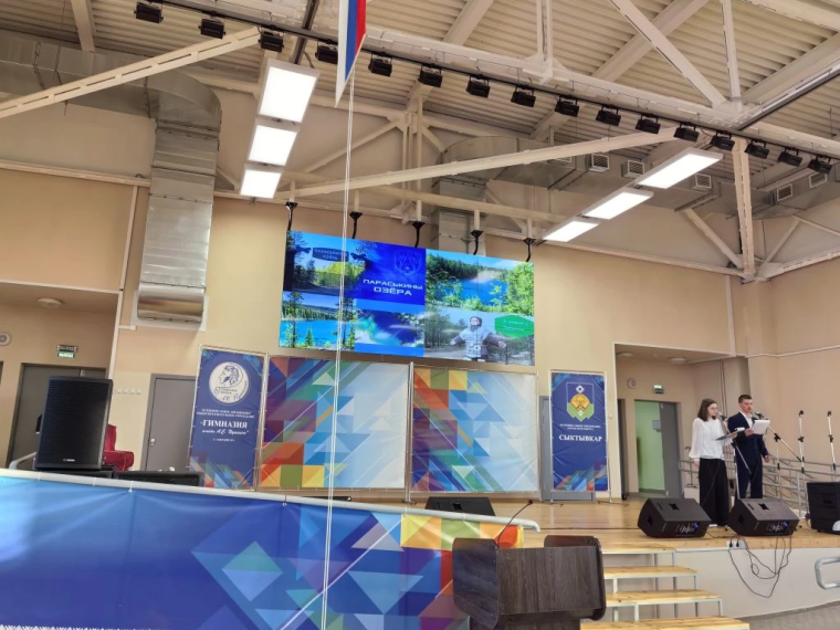 Гимназисты выступают с докладом на сене актового зала Гимназии.